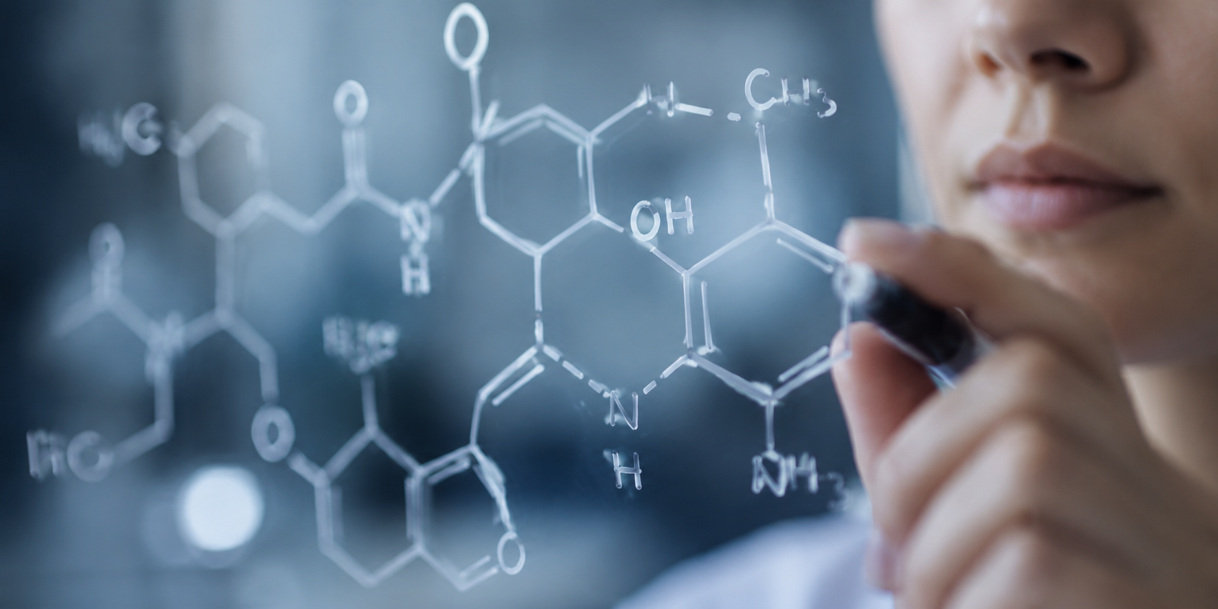 Person holding a pen with molecular structure diagram on a blurred background